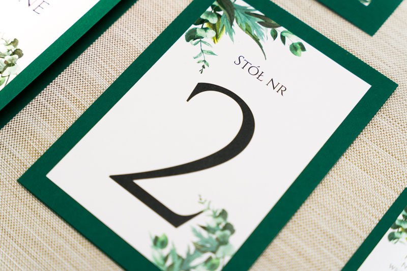 stylowe numery na stoliki na weselu z zielonymi listkami